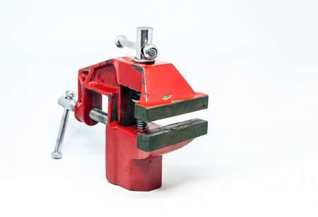 close-up view of a red steel bench vise isolated on a white background. Working tool. Table vise.の写真素材