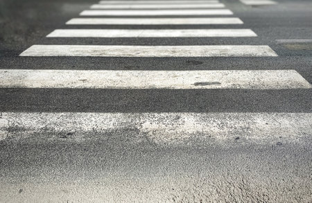 pedestrian crossing of a street with worn and ruined asphalt. Zebra crossing in a European city. Road signs and pedestrian crossing. Road safetyの写真素材