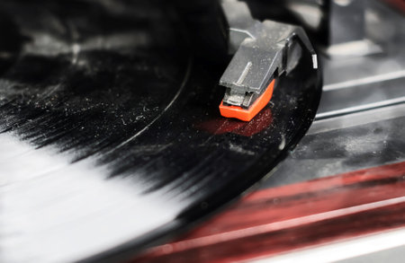the needle of a turntable playing the tracks of a black vinyl record. Vintage audio equipment. Vinyl record playerの写真素材