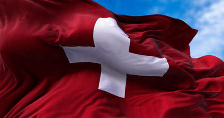 Detail of the national flag of Switzerland flying in the wind. Democracy and politics. European...