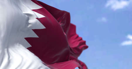 Detail of the national flag of Qatar waving in the wind on a clear day. Western asia country. Patriotism. Selective focus.の写真素材