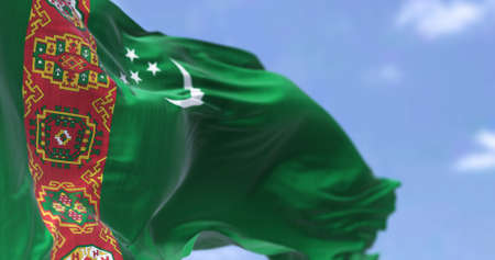 Detail of the national flag of Turkmenistan waving in the wind on a clear day. Turkmenistan is a landlocked country in Central Asia. Selective focus.の写真素材