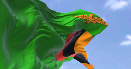Detail of the national flag of Zambia waving in the wind on a clear day. Zambia is a landlocked country at the crossroads of Central, Southern and East Africa. Selective focus.の写真素材