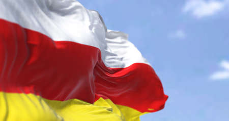 Detail of the national flag of South Ossetia waving in the wind on a clear day. South Ossetia is a breakaway state in the South Caucasus. Selective focus.の写真素材