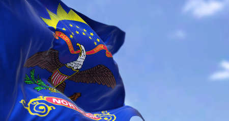 The US state flag of North Dakota waving in the wind. North Dakota is a U.S. state in the Upper Midwest region of the United States. Democracy and independence.の写真素材