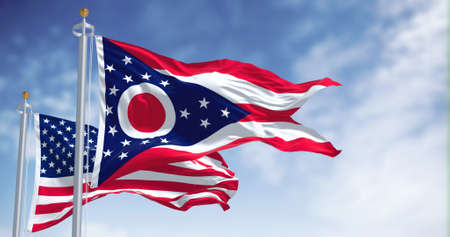 The Ohio state flag waving along with the national flag of the United States of America. In the...