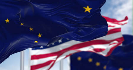 The flags of the Alaska state and United States waving in the wind. Democracy and independence. US...