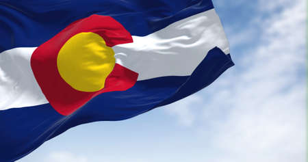the flag of the US state of Colorado waving in the wind. Colorado is a state in the Mountain West subregion of the Western United Statesの写真素材