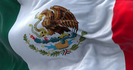Close-up view of the mexican national flag waving in the wind. Mexico is a country in the southern portion of North America. Fabric textured background. Selective focusの写真素材