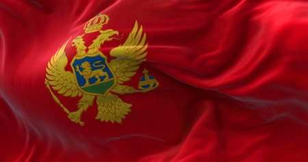 Close-up view of the Montenegro national flag waving in the wind. Montenegro is a country in Southeastern Europe. Fabric textured background. Selective focusの写真素材
