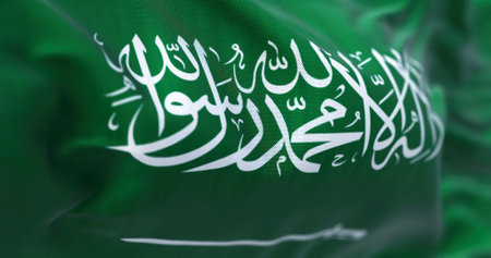 Close-up view of Saudi Arabia national flag waving in the wind. The Kingdom of Saudi Arabia (KSA) is a country on the Arabian Peninsula in Western Asia. Fabric textured background. Selective focusの素材 [FY310191587021]