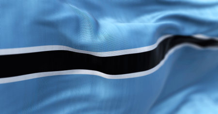 Close-up view of the Botswana national flag waving in the wind. The Republic of Botswana is a country in Southern Africa. Fabric textured background. Selective focusの写真素材
