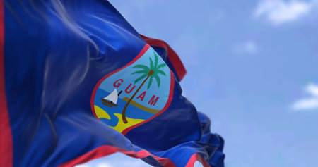 Flag of Guam waving in the wind on a clear day. Guam is an organized, unincorporated territory of the United States in the Micronesia subregion of the western Pacific Oceanの写真素材