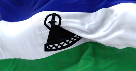 Close-up view of the Lesotho national flag waving. The Kingdom of Lesotho is a state in southern...
