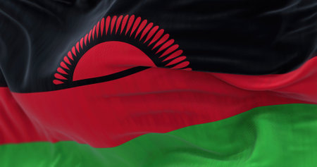 Close-up view of Malawi National flag waving. The Republic of Malawi is a landlocked country in Southeastern Africa. Fabric textured background. Selective focus. 3D illustration renderの写真素材