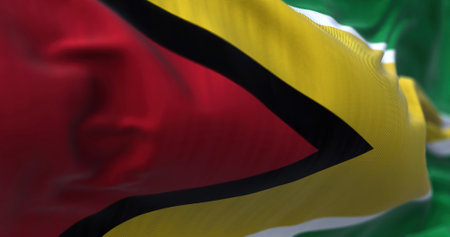 Close-up view of the Guyana national flag waving in the wind. The Coâoperative Republic of Guyana is a country on the northern mainland of South America. Fabric textured background. Selective focusの写真素材