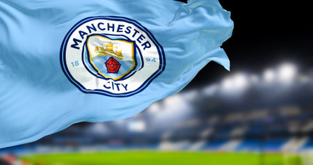 Manchester, UK, Nov 2022: Manchester City Football Club flag waving in the club stadium blurred in...