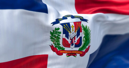 Close-up of the Dominican Republic flag. Red and blue flag with white cross, coat of arms in center....