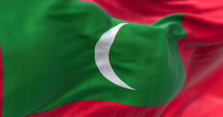 Detail of the Maldives national flag fluttering. Flag is a green rectangle on red, with a white...