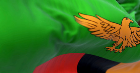 Zambia national flag waving. Green with an orange eagle in flight over a block of three vertical stripes in red, black, and orange. Fabric textured background. Selective focus. 3d illustration renderの写真素材