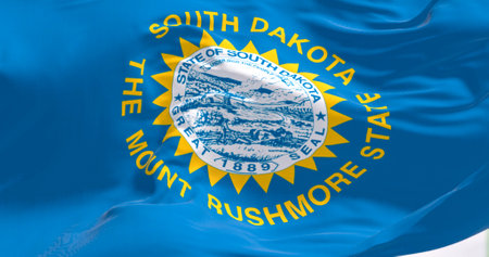 Close-up of South Dakota flag waving in the wind. Sky blue field with state seal and golden sun. US state. 3d illustration render. Close-up. Rippled textileの写真素材