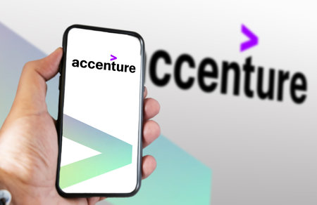 New York, US, March 2023: Hand holding a phone with Accenture logo displayed on the screen. Accenture is a multinational company that deals with business consulting. Illustrative editorialのeditorial素材