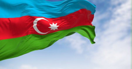 The national flag of Azerbaijan waving in the wind on a clear day. Horizontal tricolour of blue,...