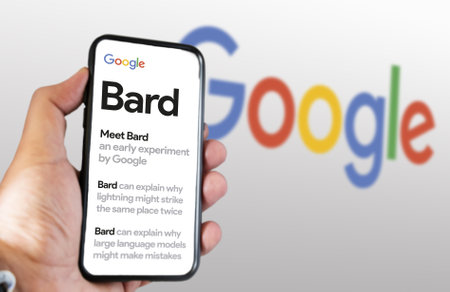 San Francisco US, Feb 2023: A hand holding a phone with the Google Bard website on the screen. White background with blurred Google logo. Bard is Google artificial intelligence chatbotのeditorial素材
