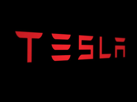 New York, US, March 2023: Red Tesla logo on a Black background. Tesla is an American multinational...