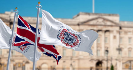 Flags with the emblem of the coronation of King Charles III and of UK waving. The emblem depicts flora of the four nations in the shape of St Edwardâs Crown. 3d illustration render. Fluttering textileの写真素材