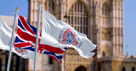London, UK, April 2023: Flags with the emblem of the coronation of King Charles III and of UK waving with Westminster Abbey in the background. Illustrative editorial 3d illustration render.のeditorial素材