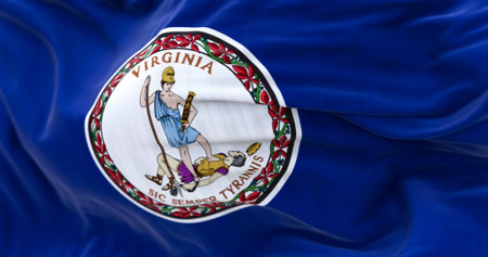 Close-up of Virginia state flag waving in the wind. Blue field with a white coat of arms in the...