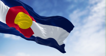 Colorado state flag waving in the wind on a clear day. Three blue, white, and blue stripes. Red C with gold disk on top. 3D illustration render. Fluttering fabric. Selective focusの写真素材