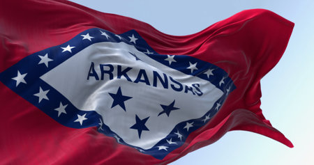 Arkansas state flag waving in the wind on a clear day. Red field with blue-bordered white diamond. 29 stars and ARKANSAS in blue. 3d illustration render. Selective focus. Fluttering fabric.の写真素材