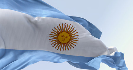 Close-up of Argentina national flag waving on a clear day. Three equal blue and white horizontal...