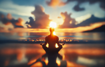 Silhouette meditating at sunset on serene seashoreの素材