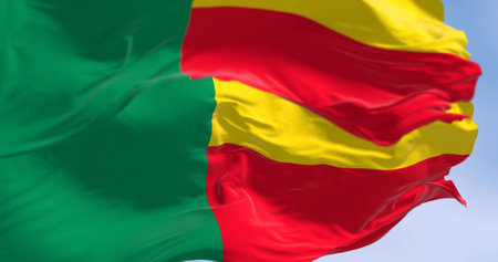 Close-up of Benin national flags waving. Two horizontal yellow and red bands on the fly side and a green vertical band at the hoist. 3d illustration render. Fluttering fabric. Selective focusの写真素材