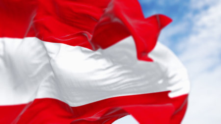 Close-up of the national flag of Austria waving on a clear day. Three equal horizontal bands: white,...