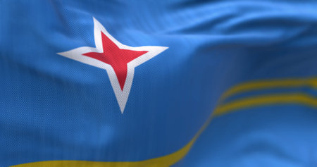 Flag of Aruba waving in the wind on a clear day. Light blue field, 2 yellow stripes, 4-pointed red star. Colors represent sea, abundance, peace, and origins. 3d illustration render. Selective focusの写真素材