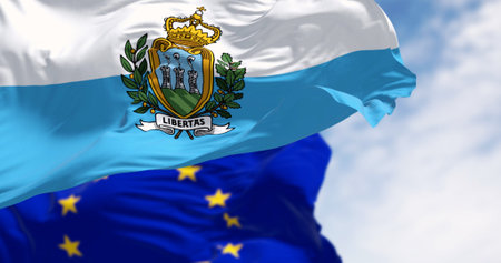 Flags of San Marino and the European Union waving in the wind on a clear day. European microstate. 3d illustration render. Fluttering fabric. Selective focusの写真素材