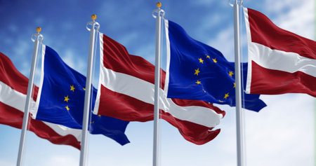 Flags of Latvia and the European Union waving on a clear day. Latvia is a member of the European Union and the Eurozone. 3d illustration render. Fluttering fabricの写真素材