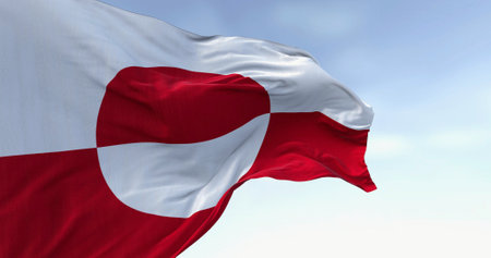 The flag of Greenland waving in the wind on a clear day. Greenland is the world's largest island, and one of the three constituent countries that form the Kingdom of Denmark,の写真素材