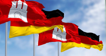 Hamburg city-state flags waving with german national flags on a clear day. 3d illustration render....