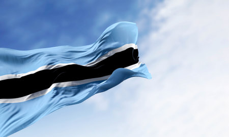 Botswana national flag waving on a clear day. Light blue field with a horizontal black and white stripe in the center. 3d illustration render. Fluttering fabric.の写真素材