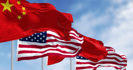National flags of China and the United States waving in the wind on a clear day. International...