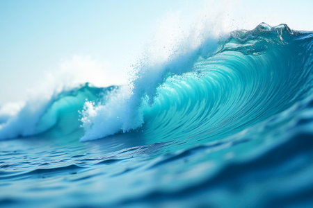 A dynamic close-up of a turquoise ocean wave curling and crashing, with water spray and sunlight reflections. The motion and energy of the sea create a sense of power, freshness, and freedom.の素材