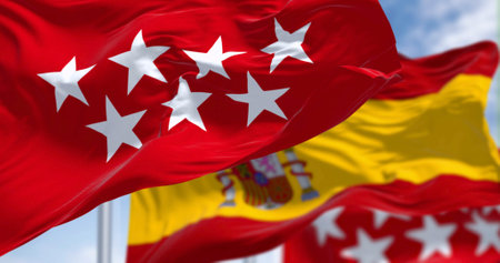 Detail of the Community of Madrid flag waving with national spanish flag. Crimson red with seven...