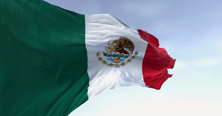 Mexico national flag waving on a clear day. Tricolor of green, white, and red with national coat of...