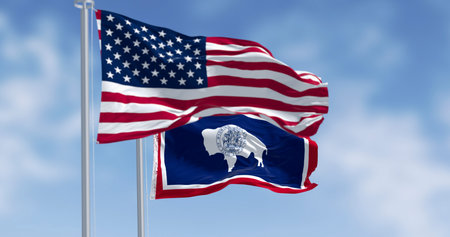 Wyoming state flag and the american flag waving together on a clear day. 3d illustration render. Selective focus. Rippling fabricの写真素材