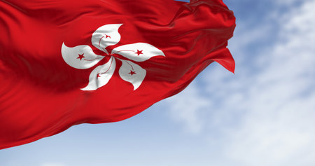 Hong Kong flag waving in the wind on a clear day. Red field with a white, stylized, five-petal Hong Kong orchid tree flower. 3d illustration render. Rippling fabric.の写真素材